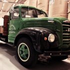 Futuristic green and bronze vehicle with heavy-duty tires parked in futuristic cityscape