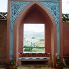 Bronze gate adorned with vines and roses in fairytale cityscape