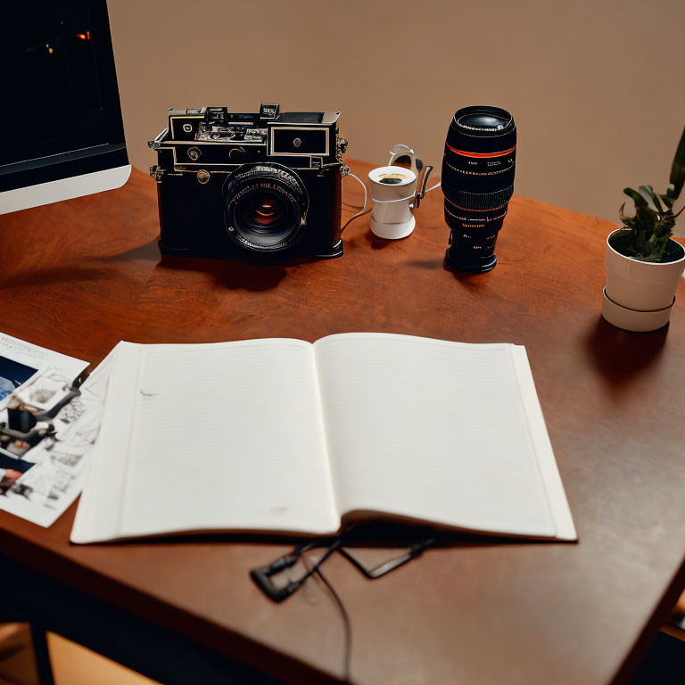 Vintage camera, lens, coffee cup, notebook, and photos on wooden desk