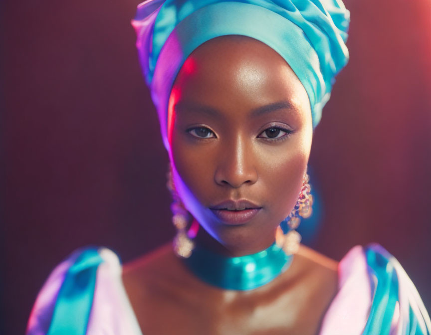 Portrait of Woman in Blue Headwrap and Earrings Against Warm Backdrop