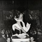 Monochrome image of dancers in motion on a stage with atmospheric lighting