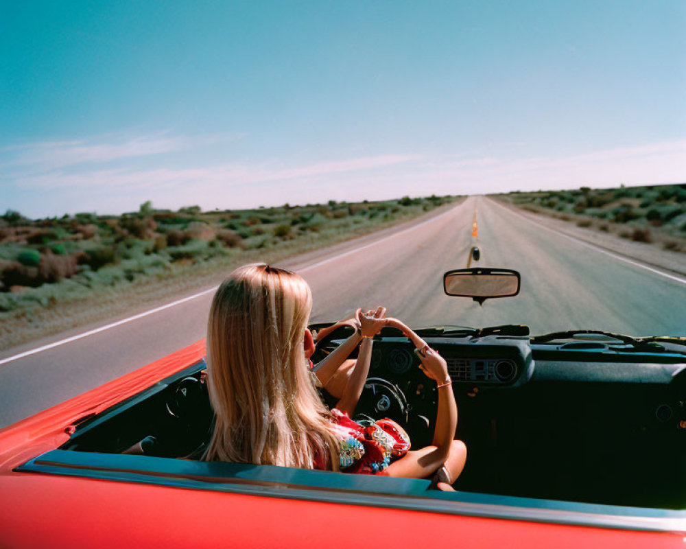 Blonde Woman Driving Red Convertible on Desert Road