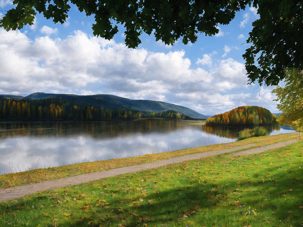 Tranquil lake with forest, hills, and pathway under cloudy sky