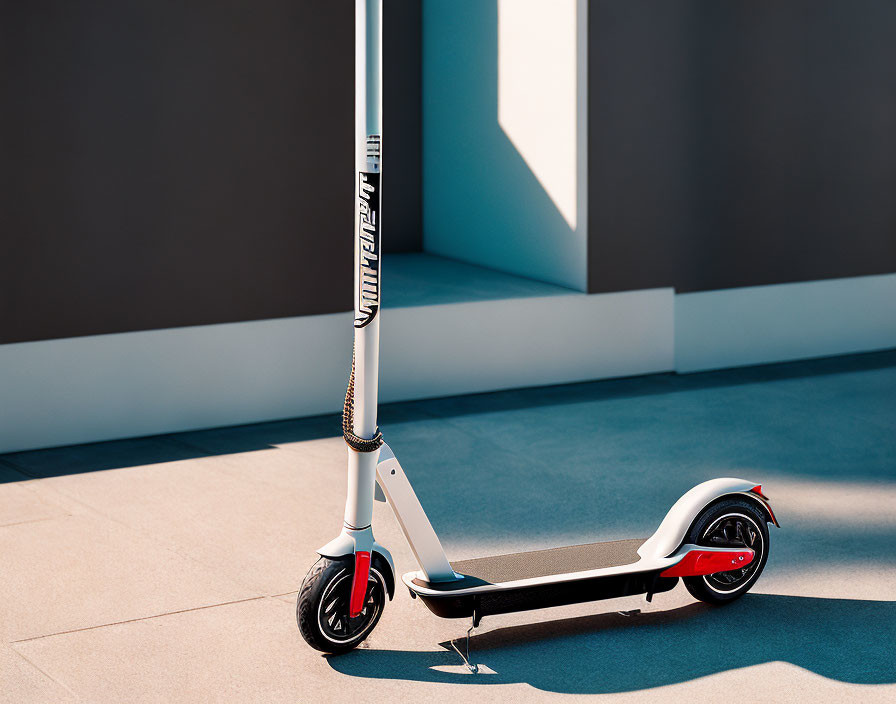 Electric scooter parked against wall with white and red accents in sunny setting