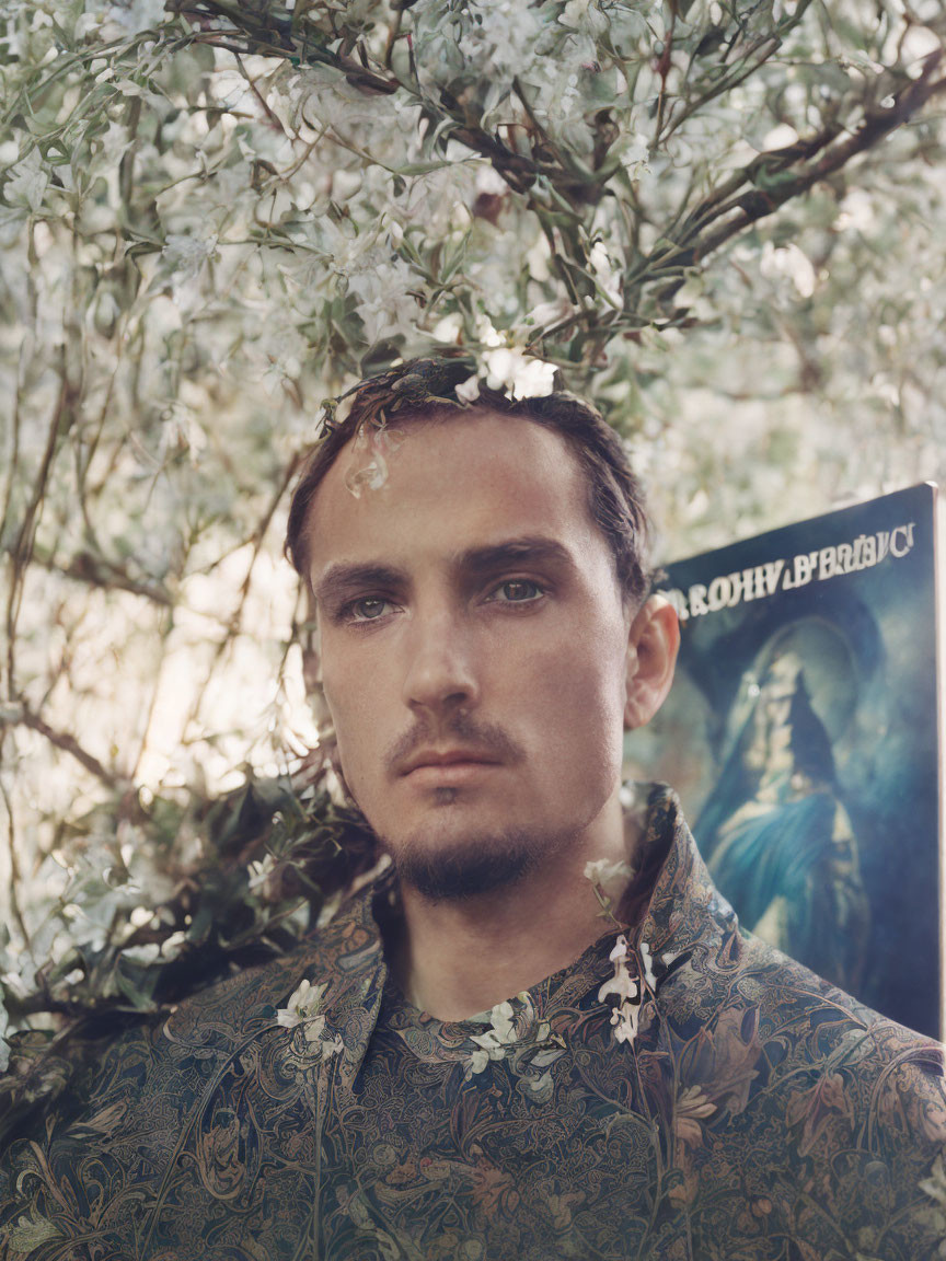 Floral Crowned Man with Cyrillic Text Book and Patterned Outfit