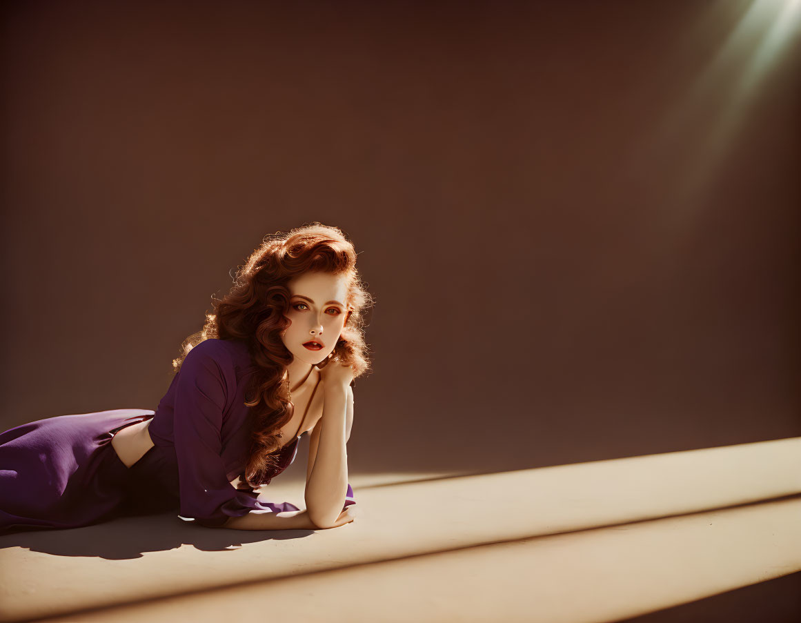 Woman with Curly Hair in Purple Dress on Beige Surface in Dramatic Lighting