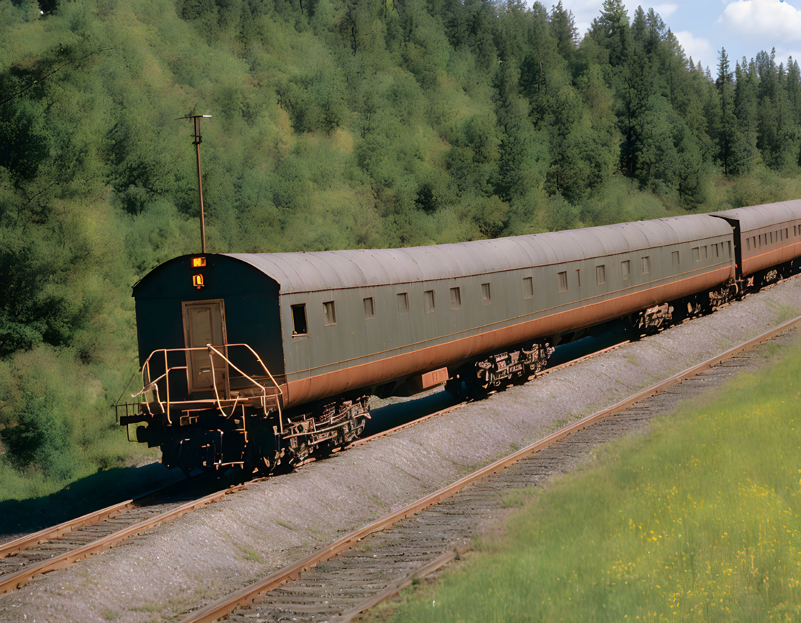 Brown Train on Track Amid Green Hills and Trees