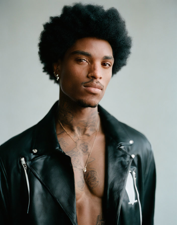 Portrait of Person with Afro, Leather Jacket, and Chest Tattoos