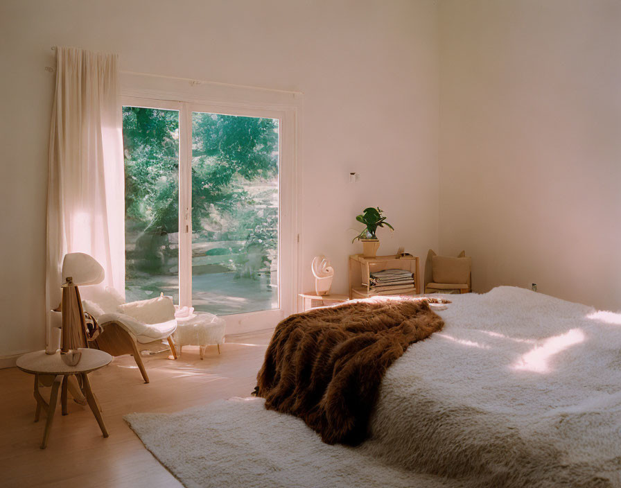 Tranquil bedroom with large window, natural light, furry blanket, and minimal decor