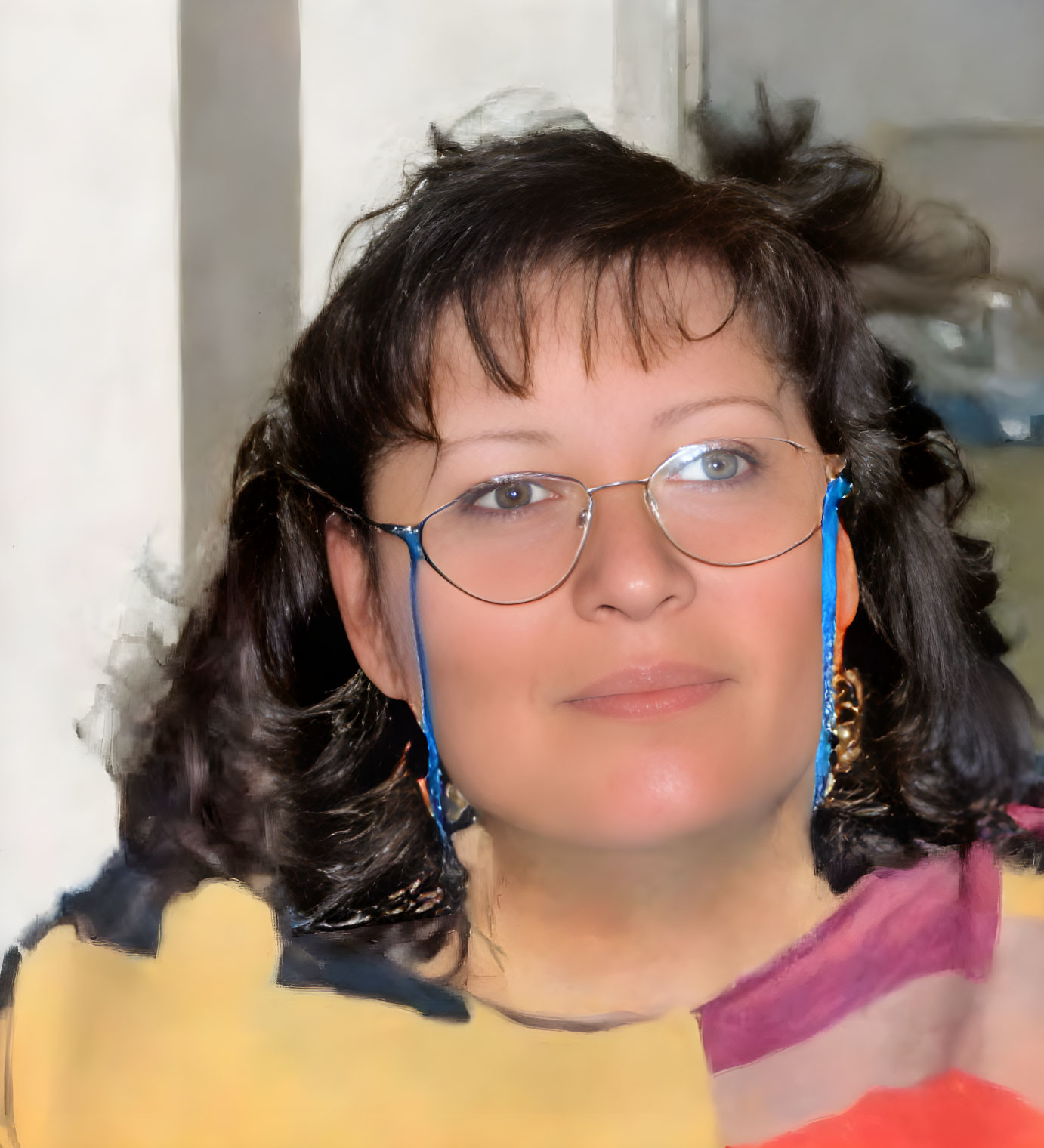 Portrait of woman with curly hair, glasses, blue earrings, in colorful collar top