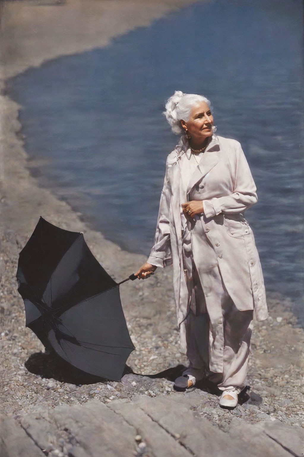 Elderly woman with white hair holding black umbrella by lake in trench coat