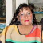 Smiling woman in glasses with colorful attire and earrings