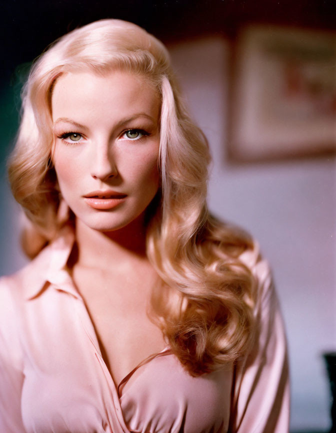 Blonde woman with wavy hair and red lipstick in pink blouse