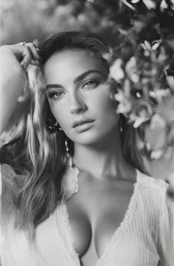 Monochrome portrait of woman with striking eyes in foliage setting