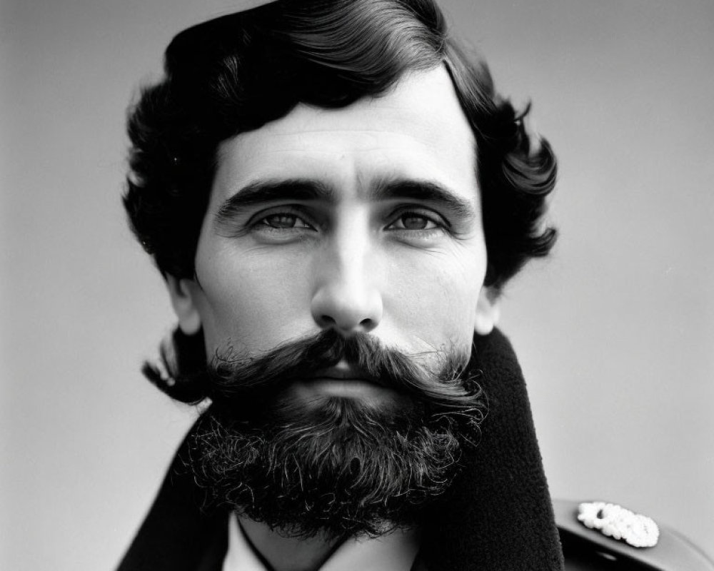 Monochrome portrait of man with styled facial hair in military uniform