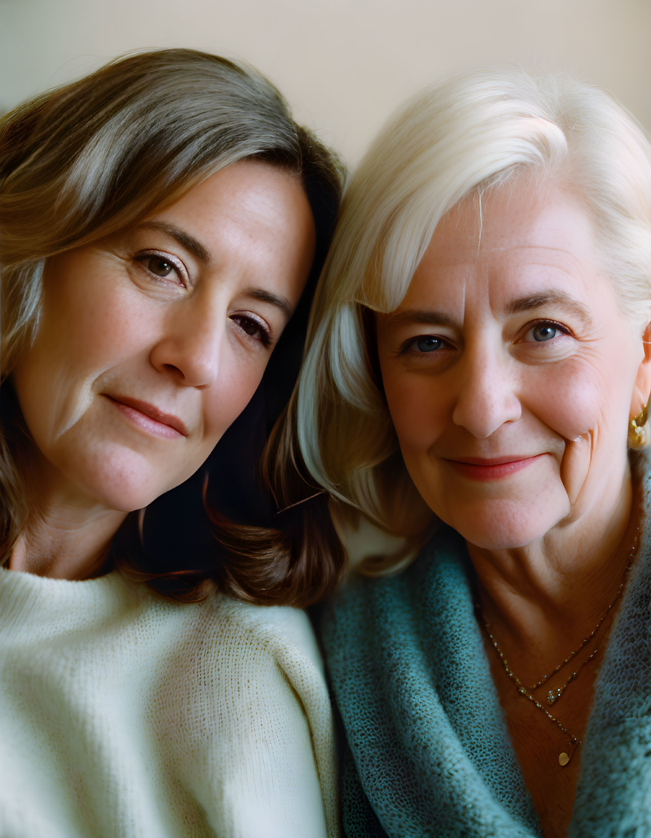 Mother and daughter posing affectionately in gentle smiles.