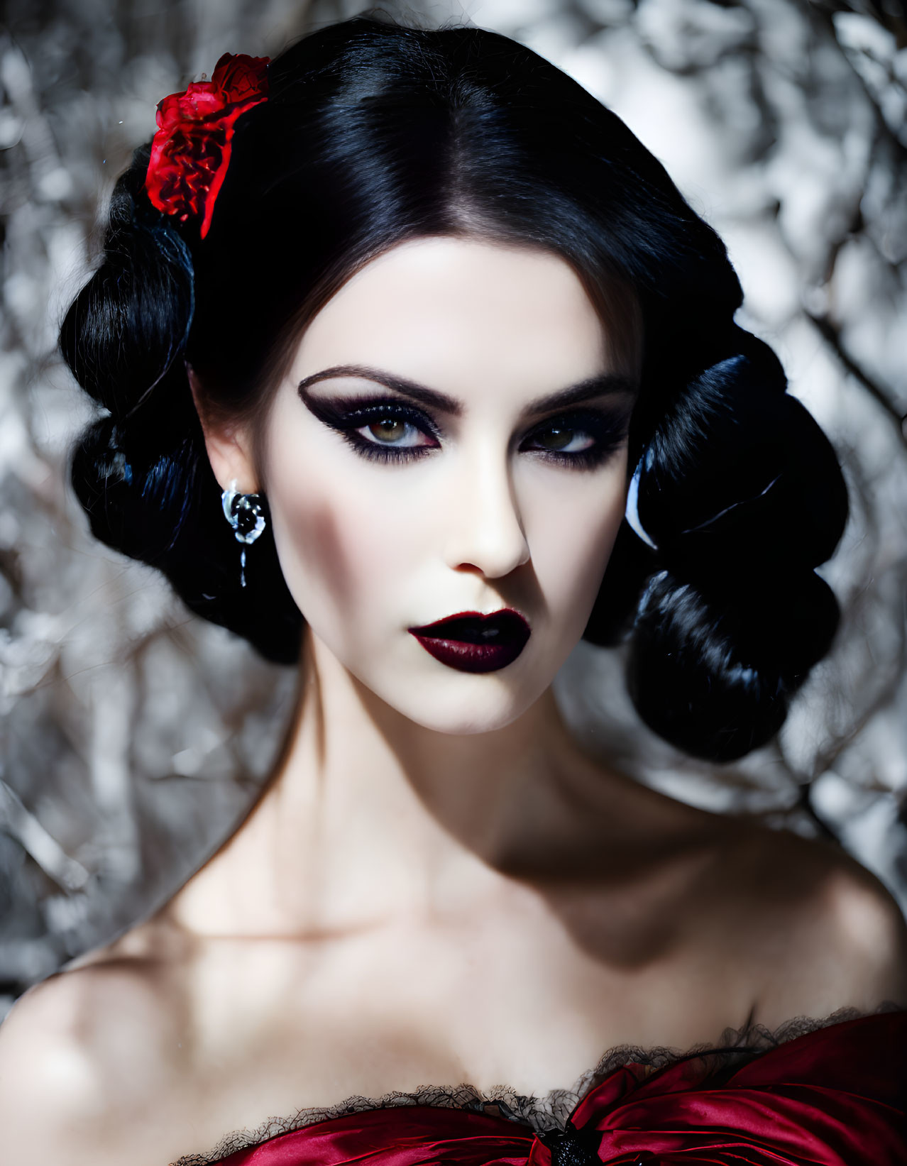 Portrait of woman with pale skin, dark makeup, red lips, black hair, and red flower accessory