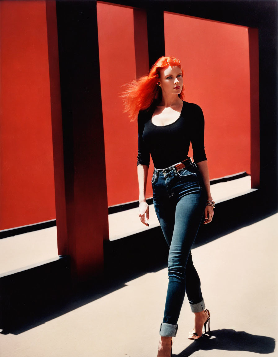 Confident woman with red hair on red and black geometric backdrop