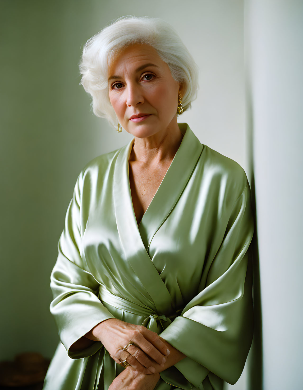 Senior Woman in White Hair and Green Silk Robe Poses Gracefully