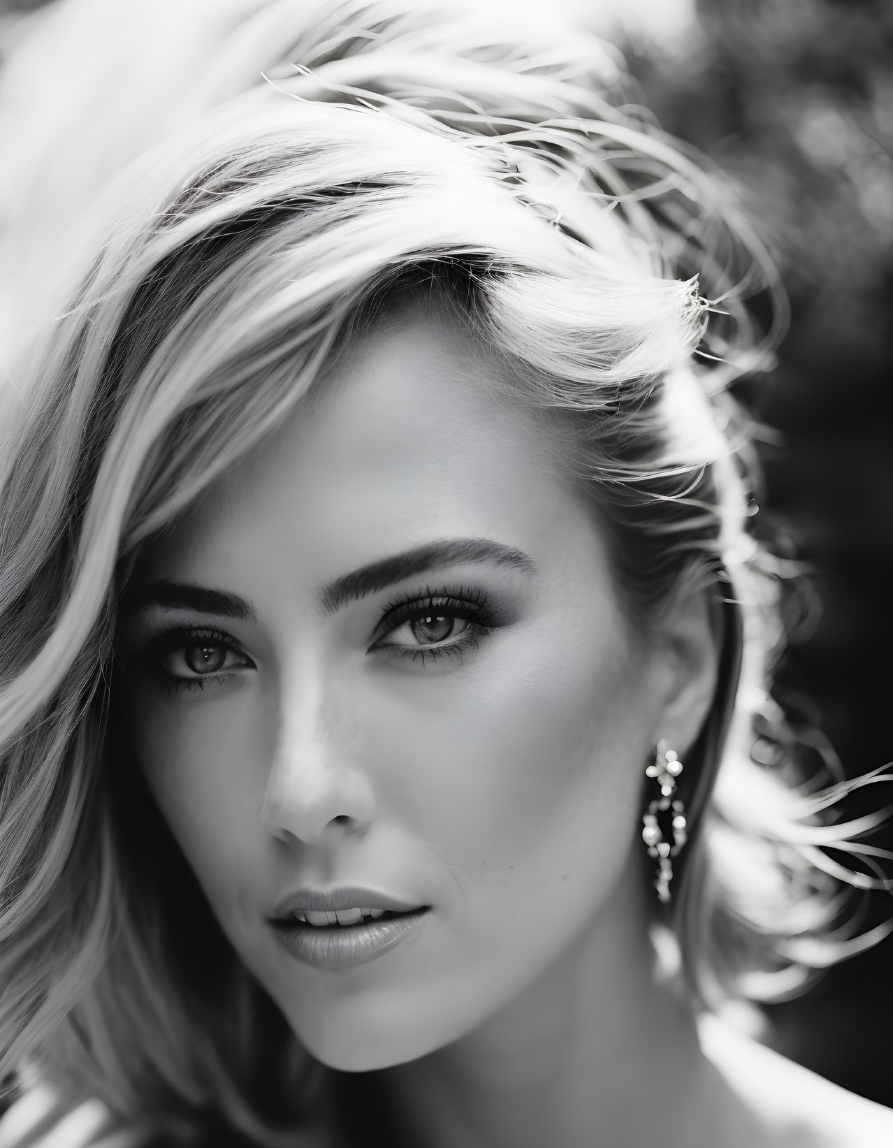 Blonde woman with striking eyes in black and white portrait