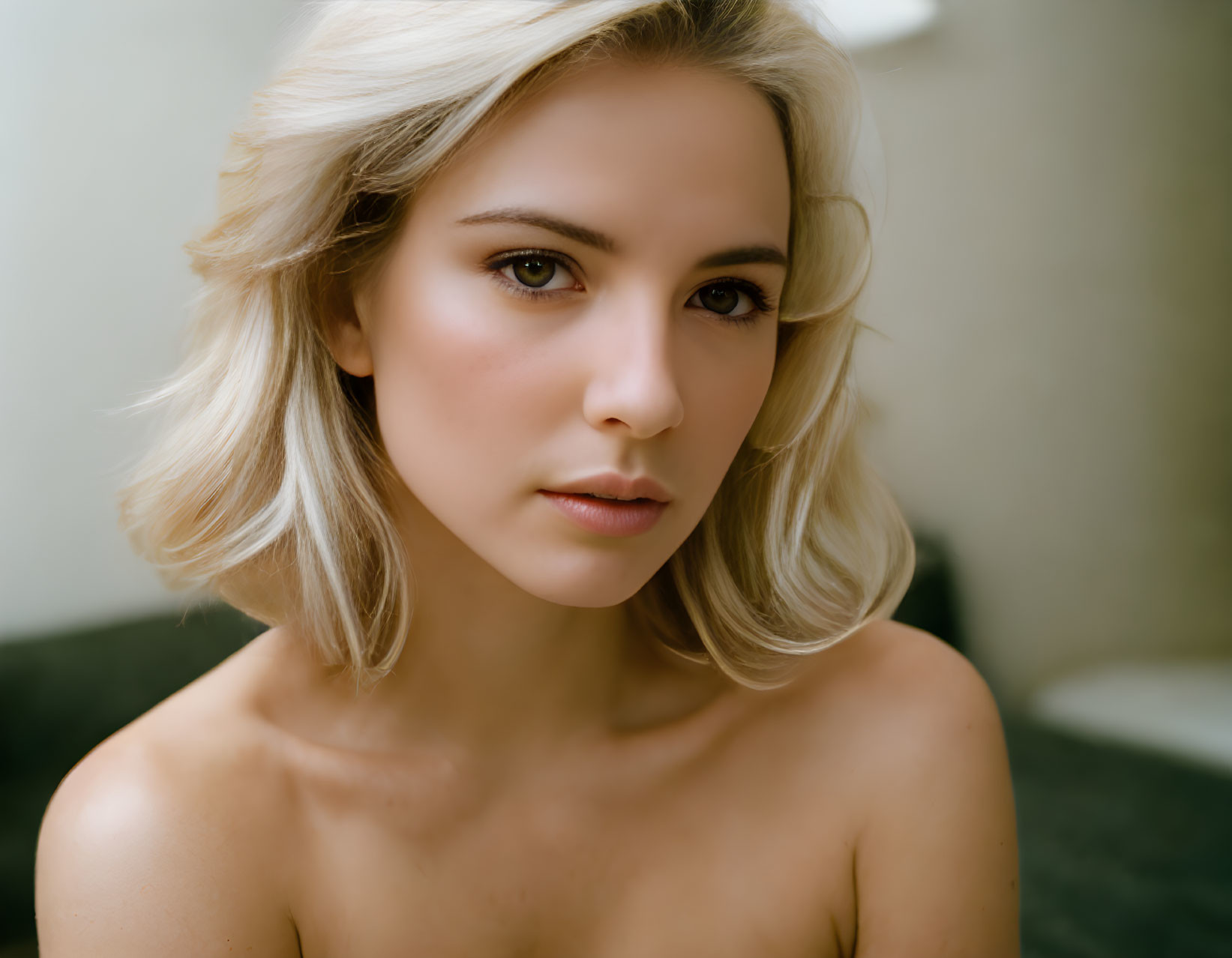 Blonde woman portrait with bare shoulders and blurred background