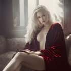 Platinum Blonde Woman in Red Robe on Sofa in Soft Light