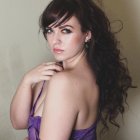 Portrait of woman with dark hair, fair skin, purple strapless top