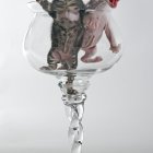 Adorable kittens with blue eyes by glass vase and purple flowers