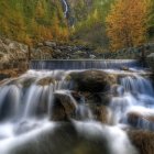 Tranquil waterfall scene with lush forest surroundings