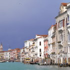 Fantasy coastal town with European-style buildings and sailboats under purple sky