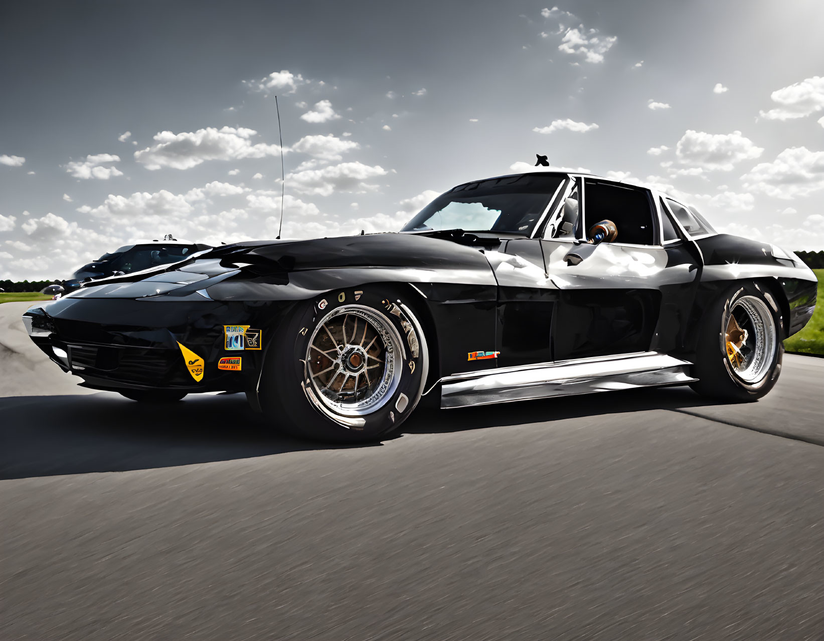 Vintage Black Corvette with Chrome Trim and Aftermarket Wheels on Sunny Day