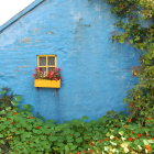 Colorful Flower-Filled Blue Cottage with Orange Door