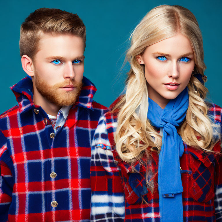 Man and woman with blue eyes in matching plaid coats on teal background.