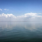 Tranquil Lake Scene with Blue Sky, Green Islands, and Colorful Flowers