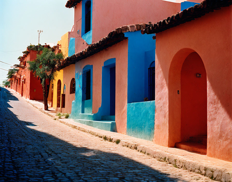 Vibrant traditional houses on cobblestone street under clear sky