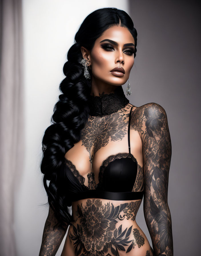 Dark-haired woman in braid with tattoos, wearing black lace attire and dramatic makeup gazes intensely