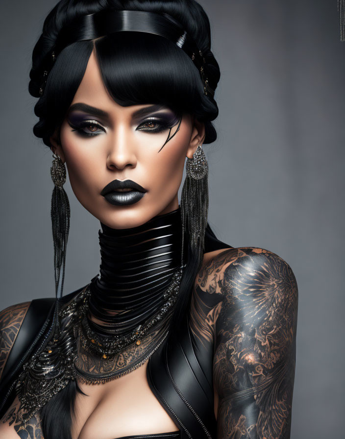 Woman with intricate tattoos and dramatic makeup against grey background