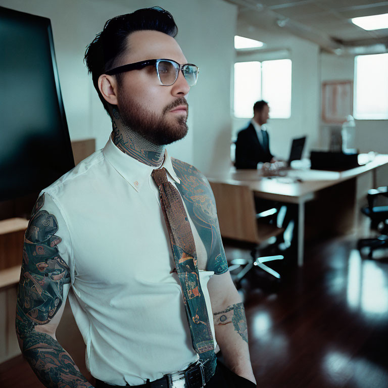 Tattooed man with glasses and suspenders in office setting