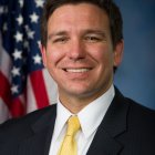 Smiling man in suit with American flag backdrop portrait