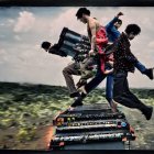 Colorful Outfit Person Jumping Above Keyboard with Cloudy Sky Background