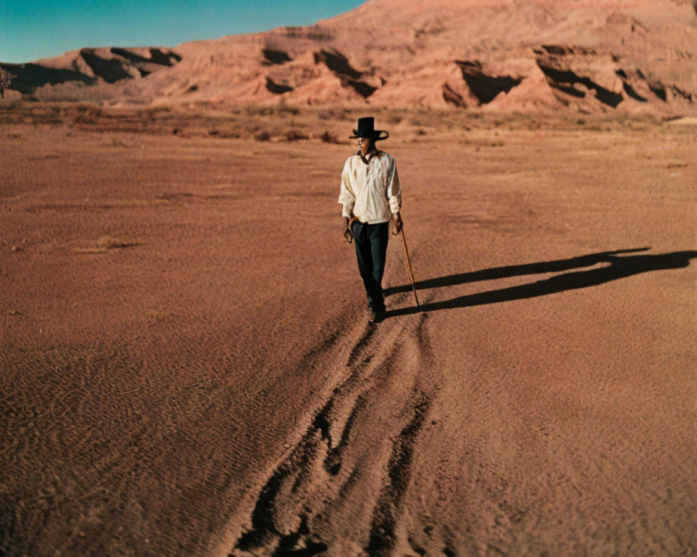 Cowboy hat figure walking in vast desert landscape