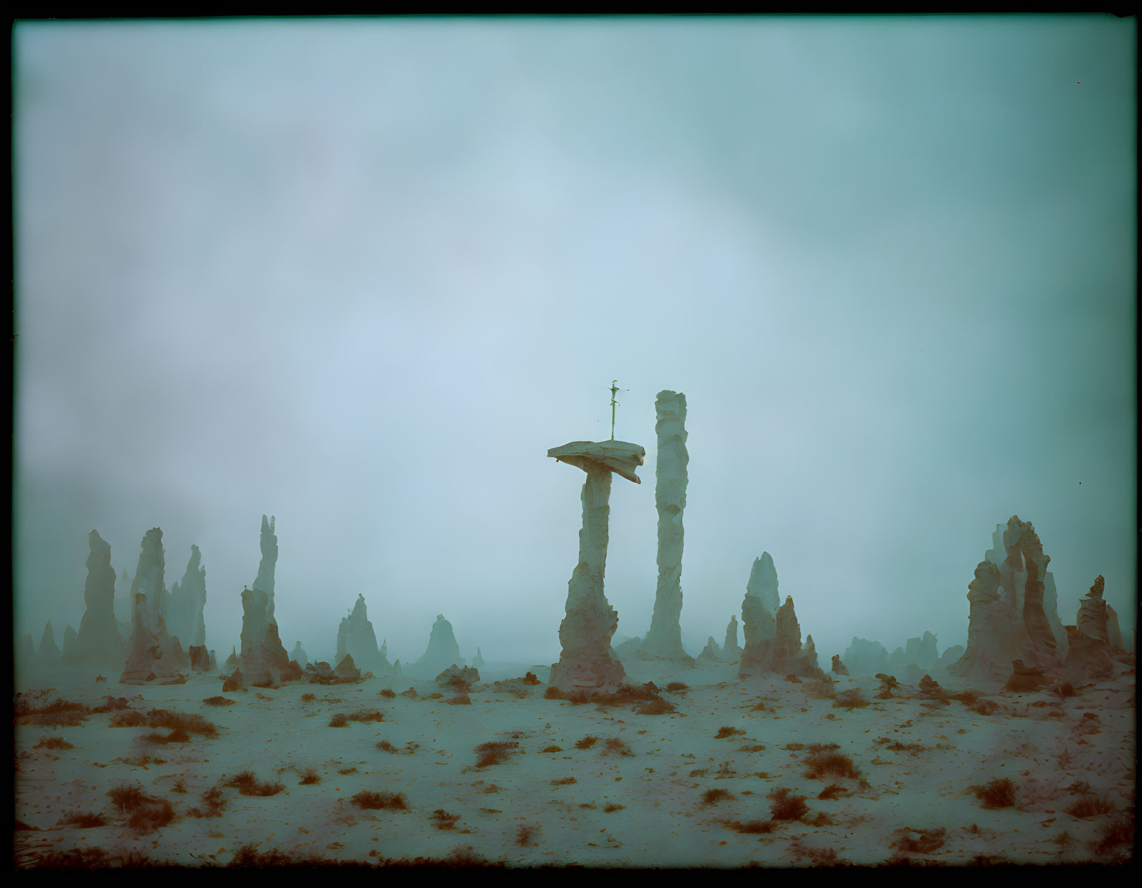 Foggy landscape with tall rock formations and weathered structure