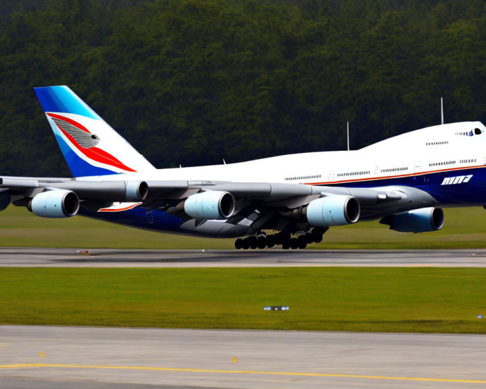 Four-engine commercial airliner with red and blue tail design on runway amidst greenery