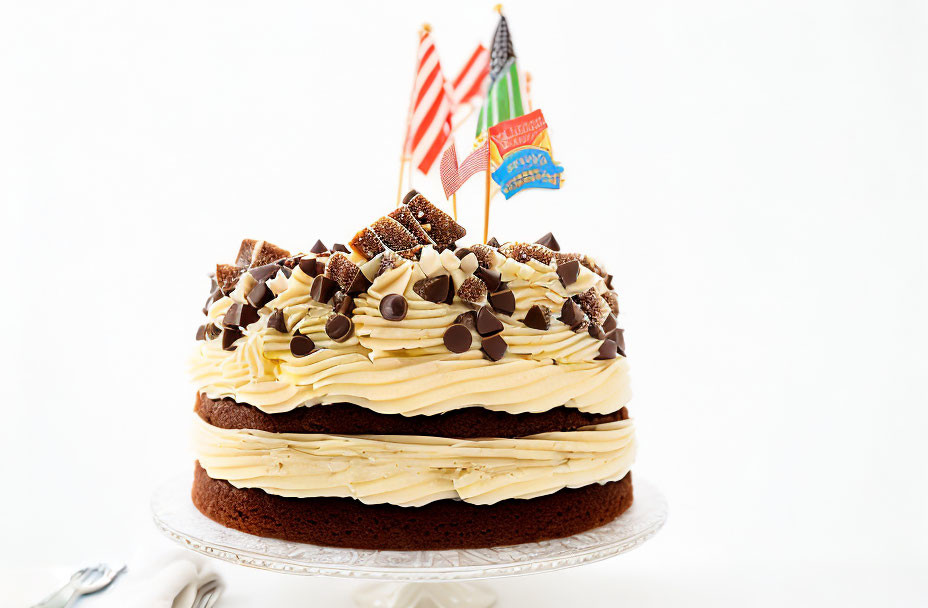 Layered Chocolate Cake with Creamy Frosting and Chocolate Pieces on Glass Stand