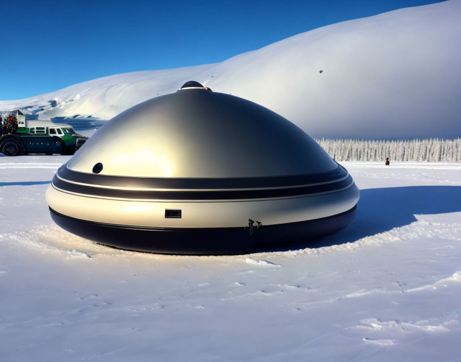 Snowy landscape with dome-shaped structure and mountains in the background