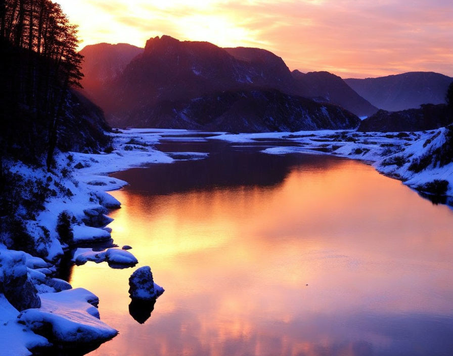 Snow-covered landscape at sunset with tranquil river and mountains