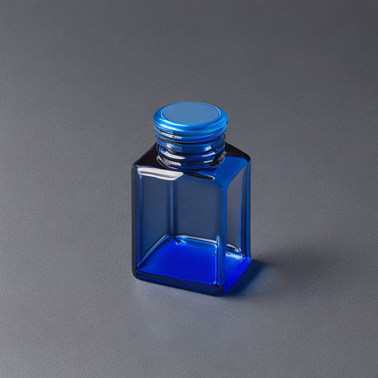 Blue Square Glass Bottle with Metallic Screw Cap on Grey Background