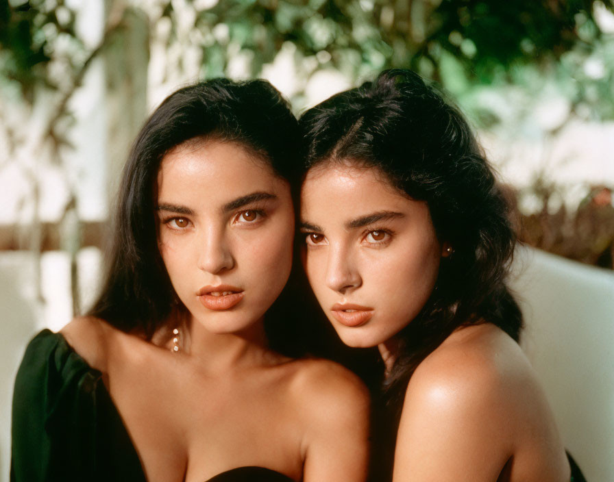 Two Women with Dark Hair Posing Closely in Green Setting