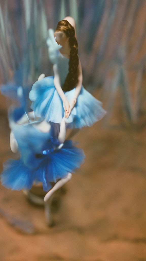 Blue dress ballerina figurine in soft focus with artistic blur effect.