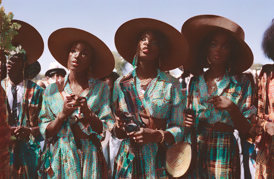 Three People in Wide-Brimmed Hats and Sunglasses with Camera on Sunny Day